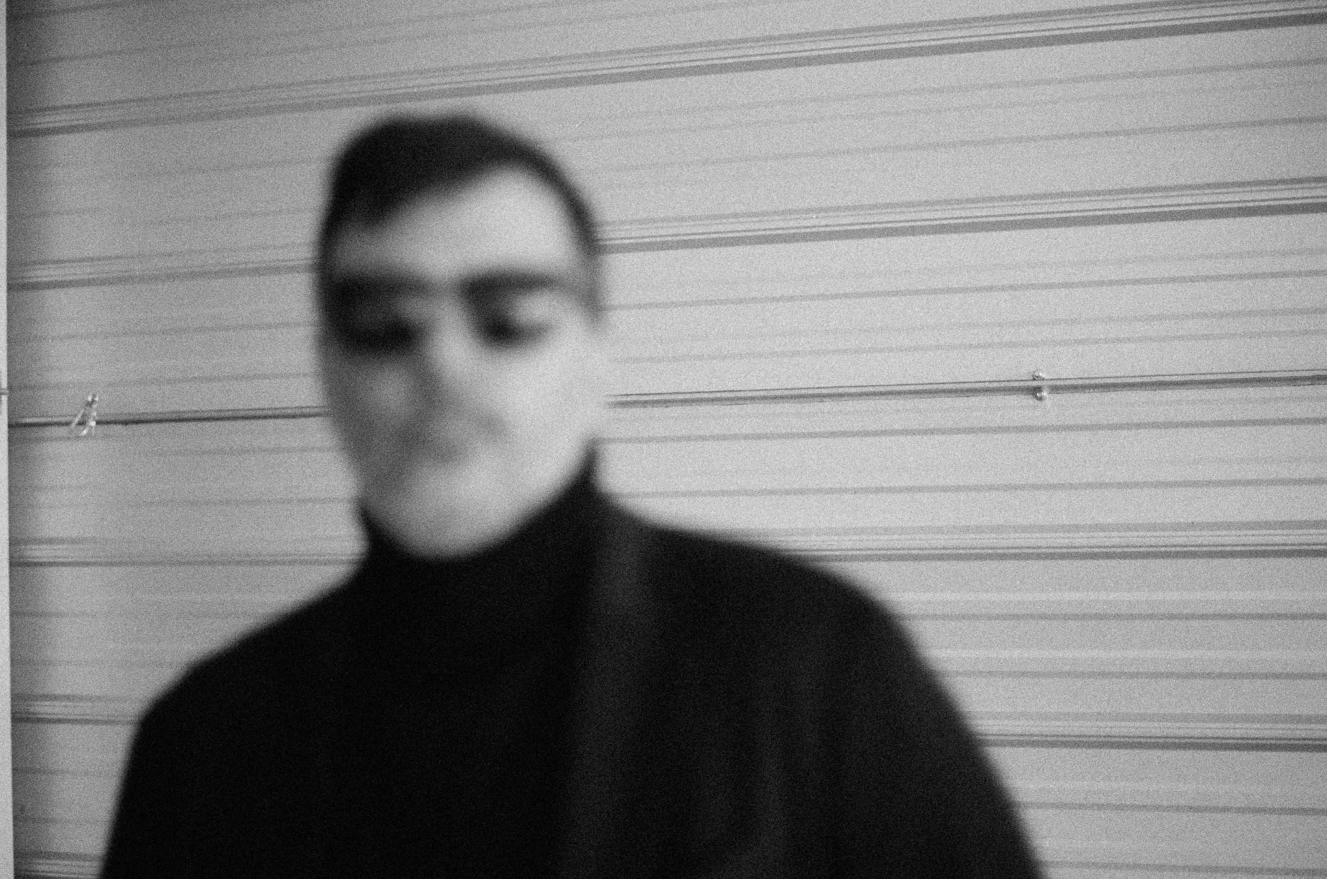 Portrait of Elias Maroun — black turtleneck against linear backdrop